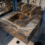 A bathroom with marble counter tops and a sink.